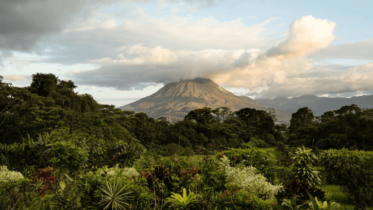 Vue sur le volcan Arenal au Costa Rica, entouré de jungle verdoyante et coiffé de nuages épais