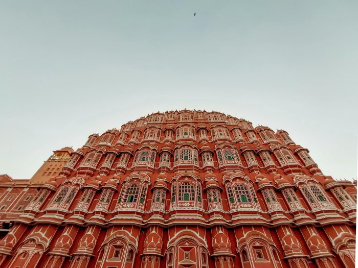 Vue du Hawa Mahal à Jaipur, majestueuse façade en grès rose percée de multiples fenêtres décorées